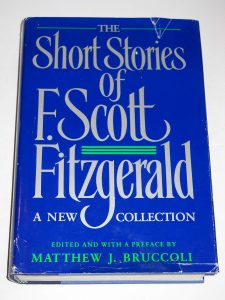 A blue hardcover book titled "The Short Stories of F. Scott Fitzgerald: A New Collection," edited and with a preface by Matthew J. Bruccoli. The dust jacket shows minor wear along the edges.