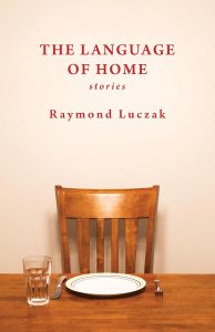 A wooden chair sits behind a table set with a glass of water, a fork, a knife, and a plate. The book title “The Language of Home: Stories” and author “Raymond Luczak” appear above the chair in red text.