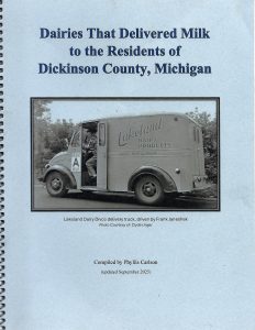 The cover of a spiral-bound book titled “Dairies That Delivered Milk to the Residents of Dickinson County, Michigan” with a black-and-white photo of a vintage Lakeland Dairy delivery truck and driver.
