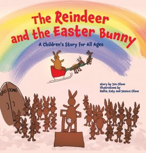 Cover of a children’s book titled “The Reindeer and the Easter Bunny,” showing a reindeer in a sleigh above a group of cartoon bunnies, with one bunny standing on a platform in front of the others.