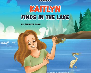 A smiling girl holds up a turtle by a lake, with a heron standing nearby and trees and blue sky in the background. The book title "What Kaitlyn Finds in the Lake" and author’s name appear at the top.