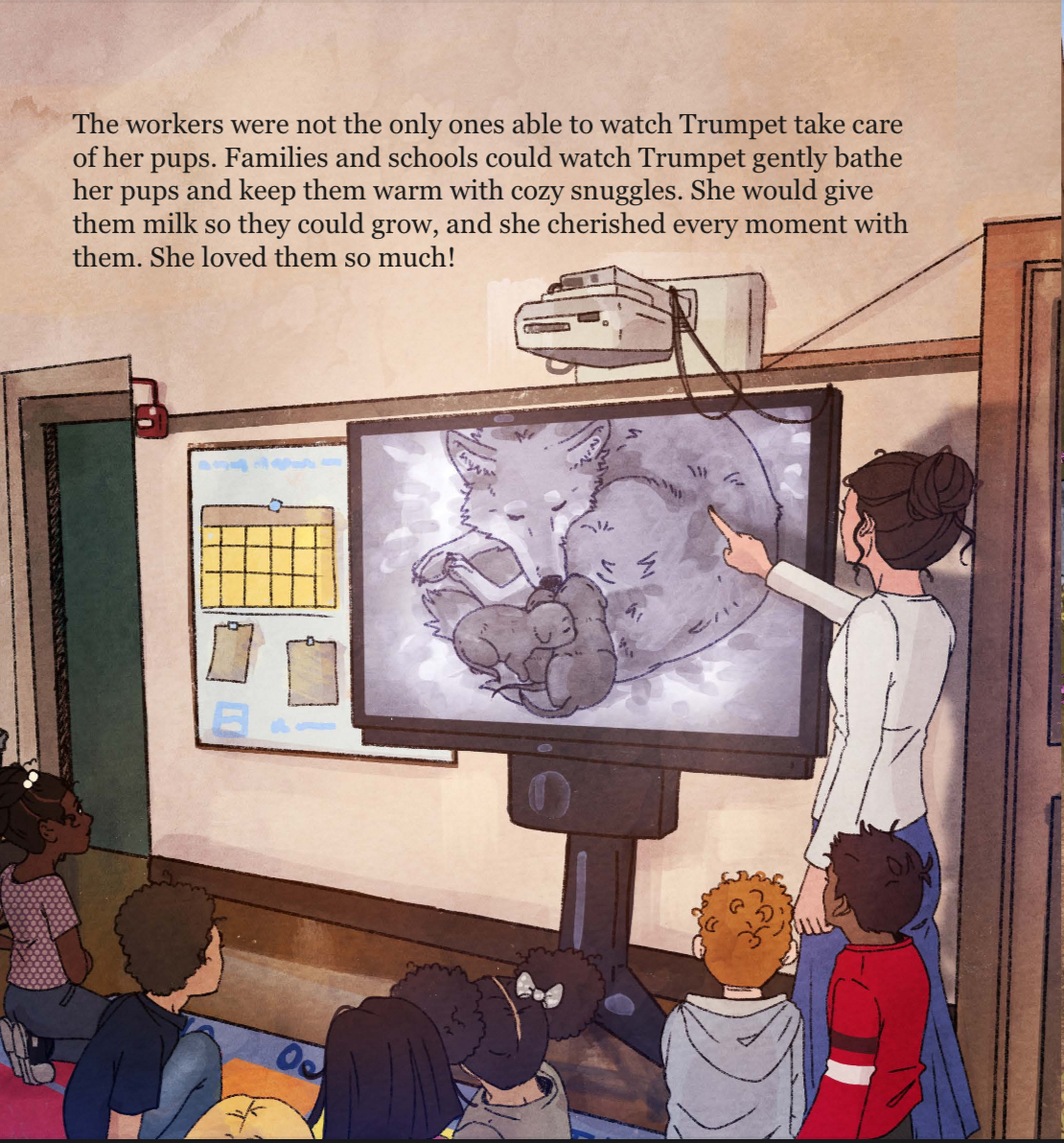 A teacher points to an image of a fox and her pups on a large classroom screen while a group of young students sit on the floor, watching and listening attentively.