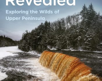 Book cover for "Michigan Revealed: Exploring the Wilds of Upper Peninsula" by Leslie Ciepłechowicz, featuring a river waterfall surrounded by snow-covered trees under a cloudy sky.
